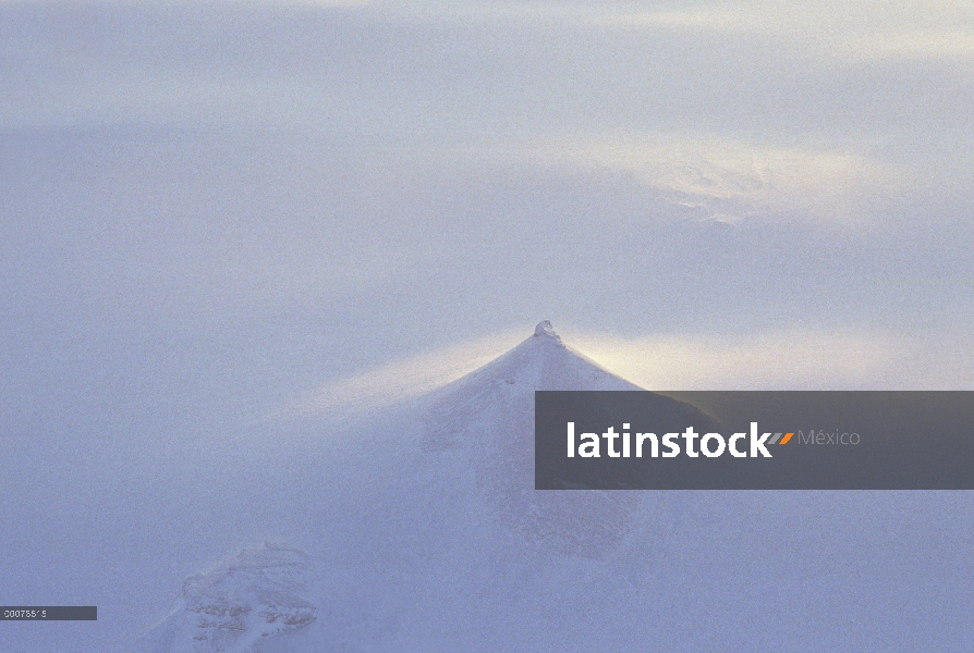 Paisaje nevado con pico sobresaliendo por encima de la niebla, isla de Ellesmere, Nunavut, Canadá