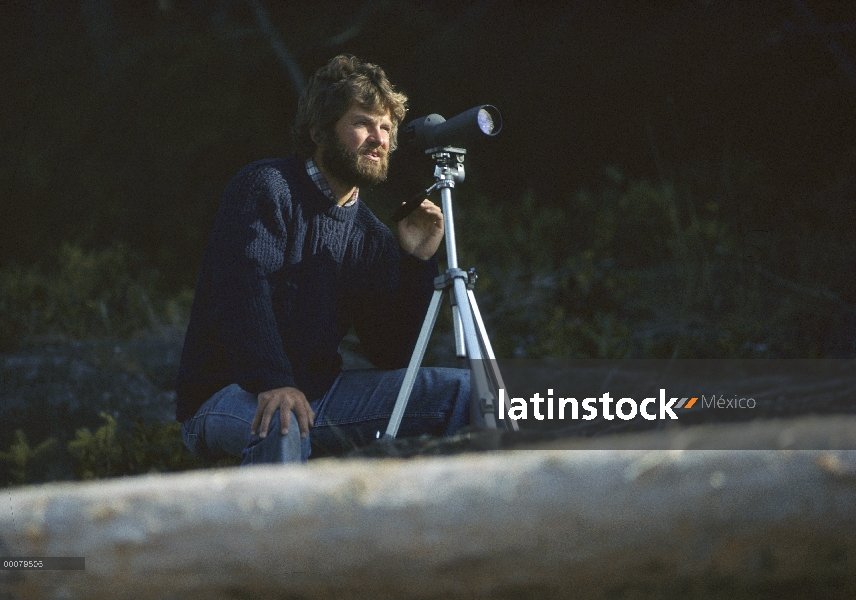 Investigador de Orca Graehme Ellis, técnico de Mike Bigg, mirando desde la orilla, isla de Vancouver