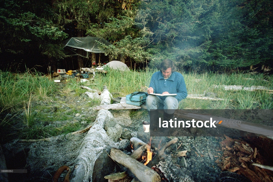 Ballena jorobada (Megaptera novaeangliae) biólogo examinar datos en campfire, Alaska