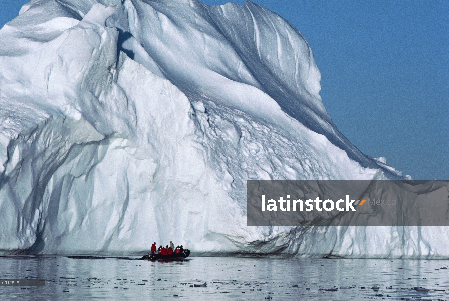 Turistas en un bote zodiac inflable acercarse a un iceberg, Antártida