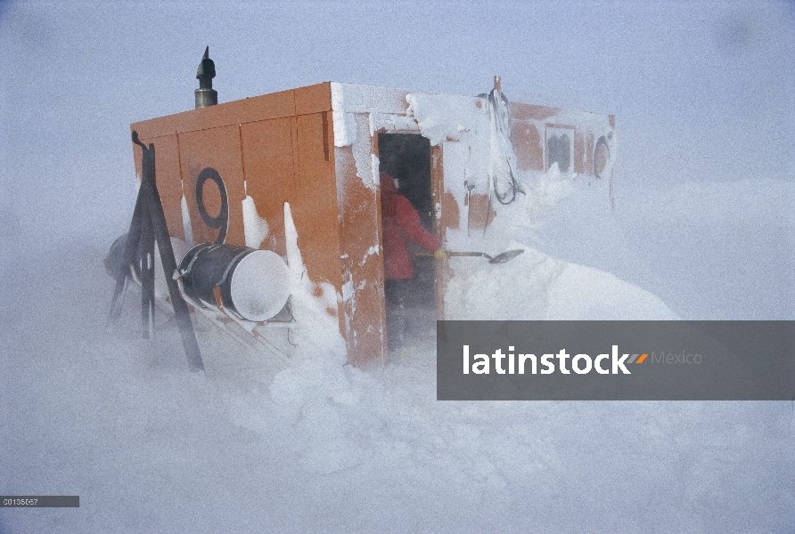 Investigador Dr. Dale Stokes prepara una cabaña de buceo después de una tormenta de nieve, U.S. base