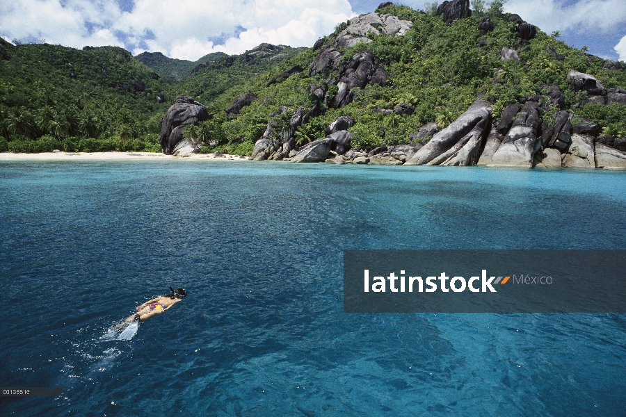 Nadador y coral de arena playas con formaciones de granito único, Seychelles