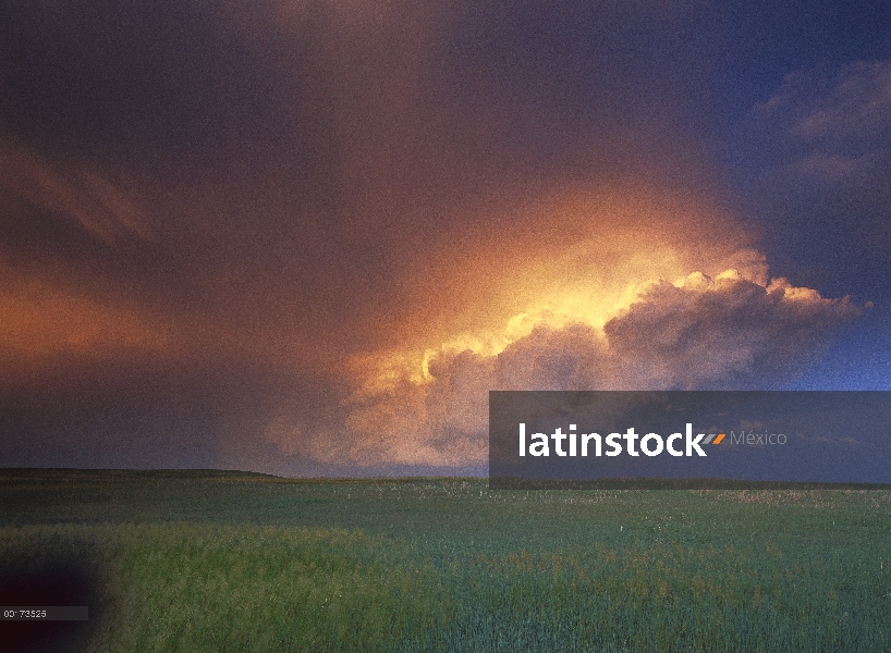 Nube de tormenta iluminada por el sol sobre la pradera, el Parque Nacional Badlands, Dakota del sur