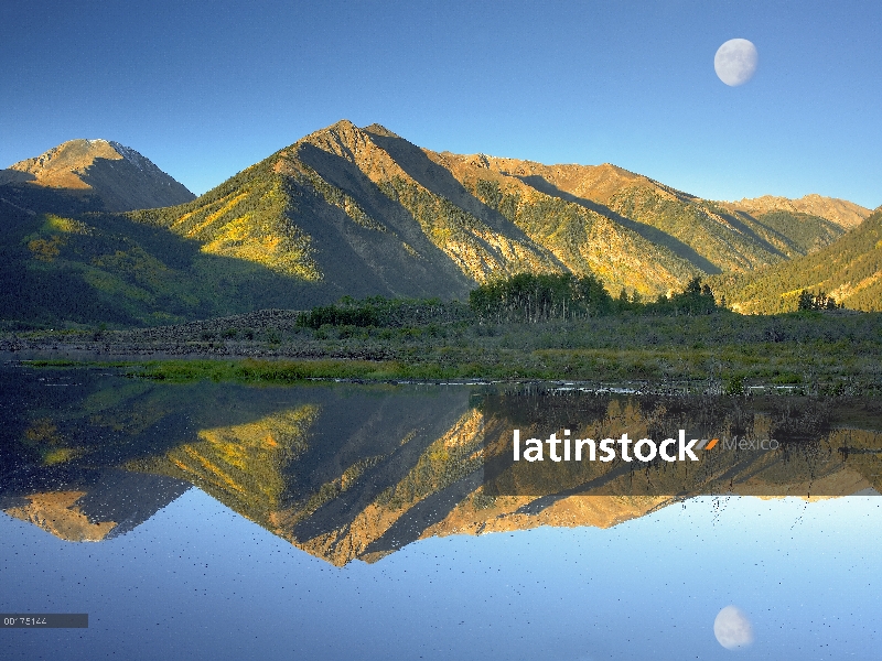 Luna y Twin Peaks reflejan en lake, Colorado