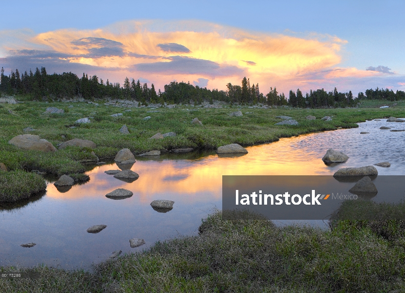 Las nubes y la puesta de sol reflejada en la corriente, meseta de Hellroaring, Montana