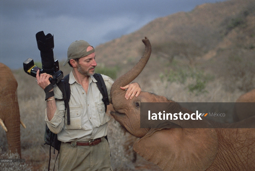 Huérfano de elefante africano (Loxodonta africana), Nyiro, diez meses de edad, con fotógrafo Gerry E