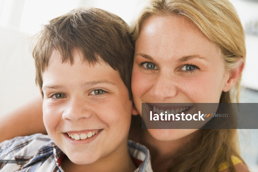 Mujer y niño joven en sala, sonriente